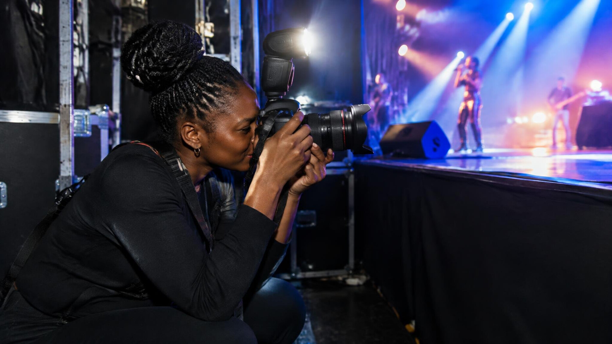 Photographer capturing a flash photo backstage during a live event
